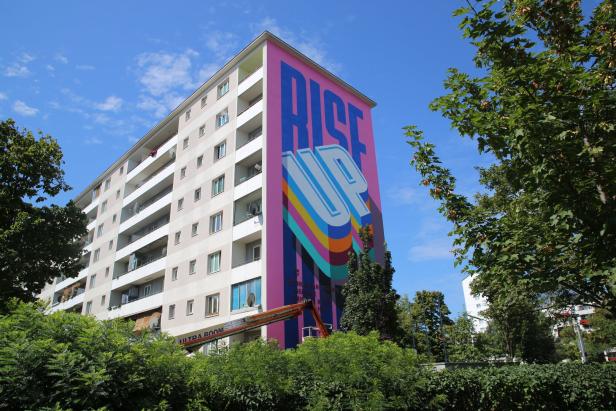 Ein Wohnhaus mit einem großen Wandgemälde mit der Aufschrift „Rise Up“ im Rahmen des Calle Libre Street Art Festivals.
