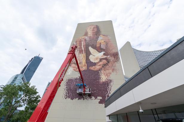 Ein Wandgemälde von Fintan Magee zeigt eine Frau mit einer Taube.