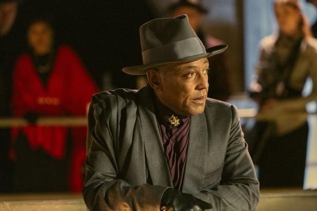 Giancarlo Esposito mit Hut und Anzug, im Hintergrund unscharfe Personen.