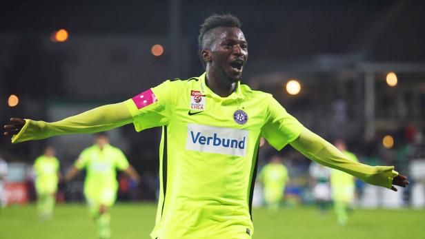 Ein Fußballspieler in einem hellgrünen Trikot jubelt auf dem Spielfeld.