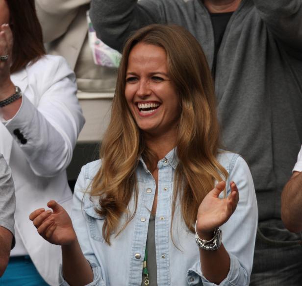 Eine lachende Frau mit blonden Haaren klatscht Beifall.