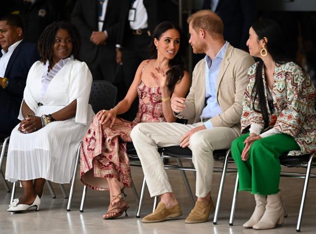 Meghan Markle und Prinz Harry sitzen mit zwei weiteren Frauen auf Stühlen.