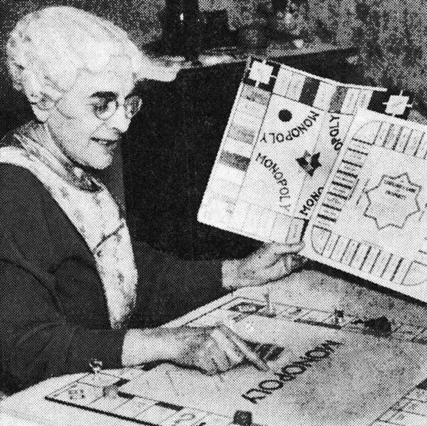 Eine Frau mit Brille spielt das Brettspiel Monopoly.