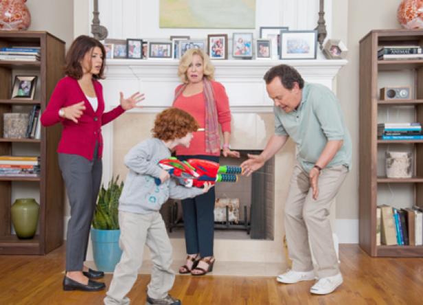 Ein Junge zielt mit einer Spielzeugwaffe, während eine Frau und zwei Erwachsene besorgt aussehen.