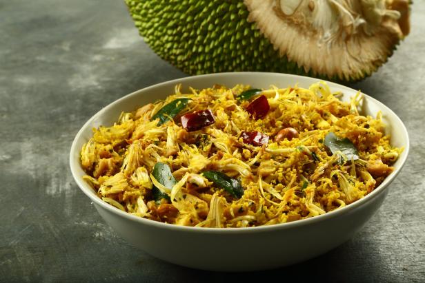Ein Gericht mit Jackfrucht, garniert mit Curryblättern und roten Chilischoten.