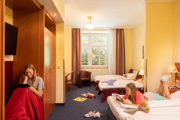 Zwei Mädchen verbringen Zeit in einem Familienzimmer des Austria Classic Hotel Wien.