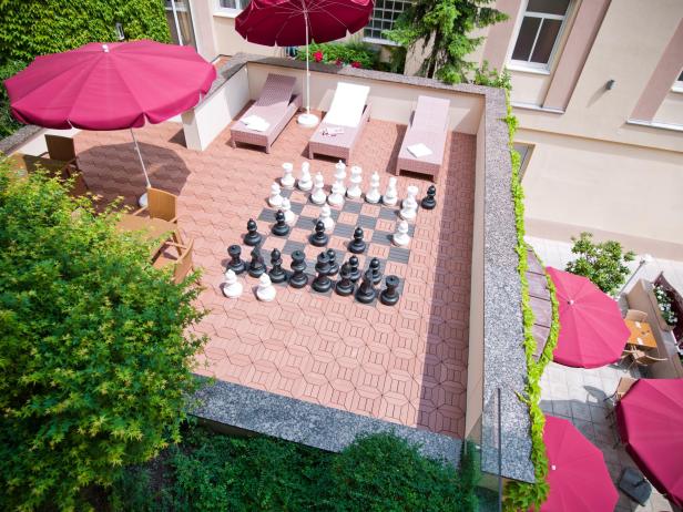 Eine Dachterrasse des Austria Classic Hotel Wien mit Liegestühlen und einem Schachspiel.
