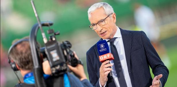 Ein Fernsehmoderator des ORF spricht in ein Mikrofon vor einem Spiel.