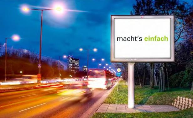 Eine Werbetafel am Straßenrand zeigt den Slogan „macht's einfach“.