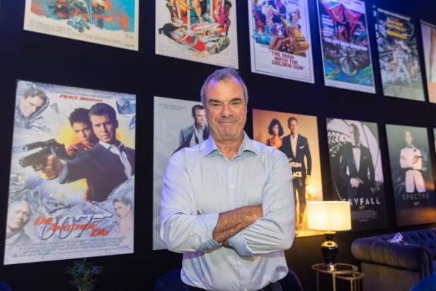 Ein Mann steht vor einer Wand mit James-Bond-Filmpostern.