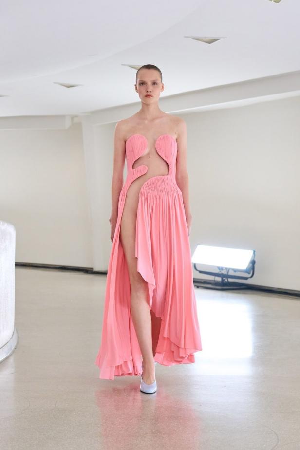 Ein Model präsentiert ein rosa Kleid von Alaïa.