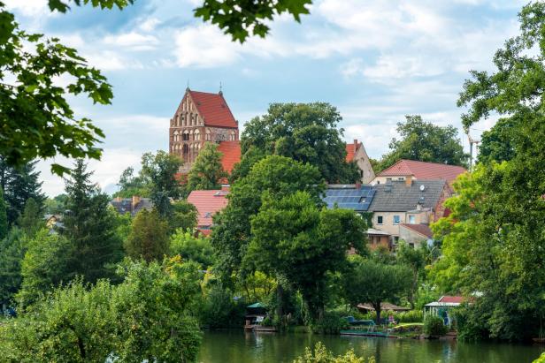 Blick über einen See auf eine Stadt mit einer Kirche im Hintergrund.