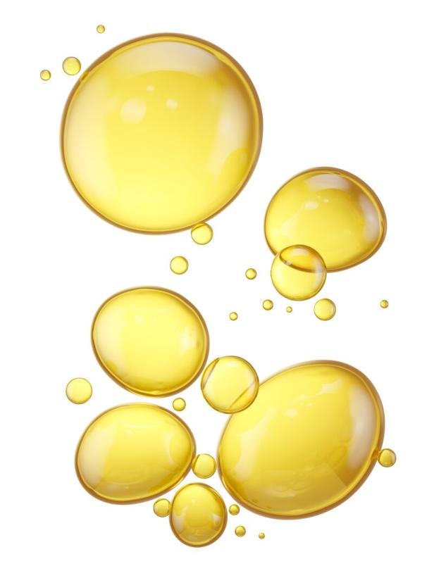 Mehrere goldene Öltröpfchen auf einem weißen Hintergrund.