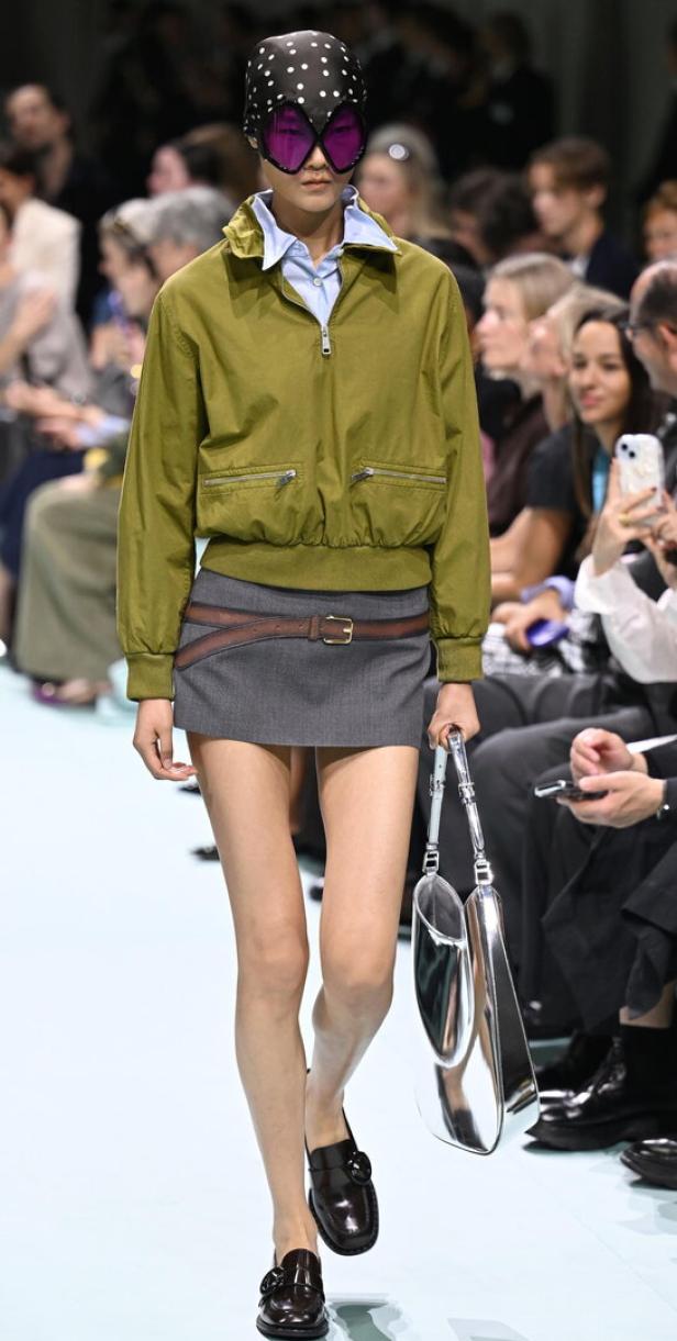 Eine Frau mit gepunktetem Kopftuch und futuristischer Brille auf dem Laufsteg.