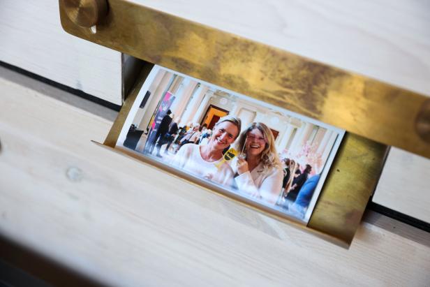 Ein Foto von zwei Frauen mit Requisiten auf einer Veranstaltung in einem goldenen Rahmen.
