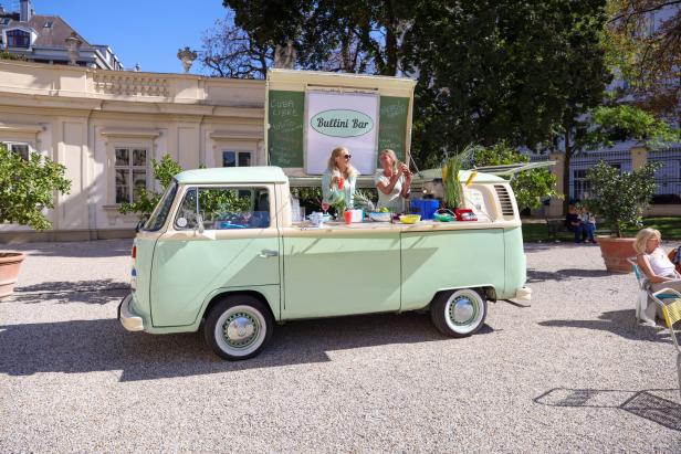 Zwei Frauen arbeiten in einer „Bullini Bar“, die in einem hellgrünen VW-Bus untergebracht ist.