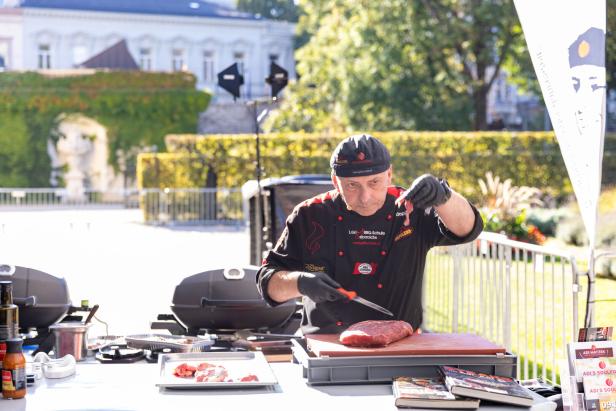 Der Grillmeister schneidet das Fleisch zurecht.