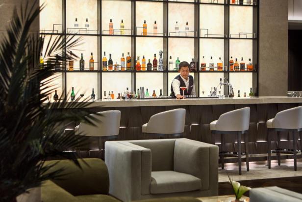 Ein Barkeeper bereitet einen Cocktail in einer eleganten Bar zu.