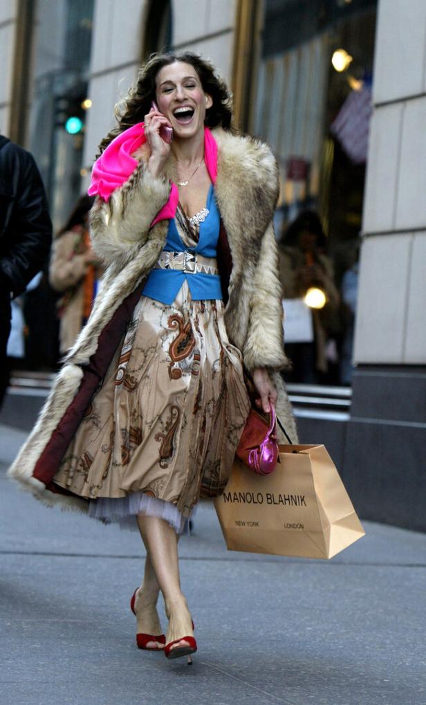 Sarah Jessica Parker, als Carrie Bradshaw, telefoniert mit einer Manolo Blahnik-Tasche in der Hand.