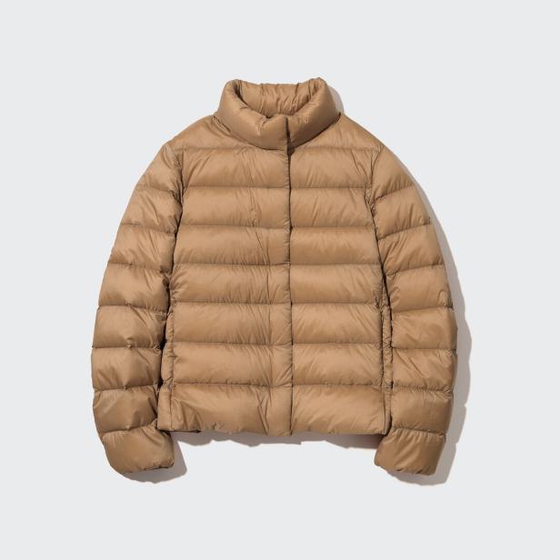 Eine hellbraune, gesteppte Daunenjacke mit hohem Kragen vor einem weißen Hintergrund.