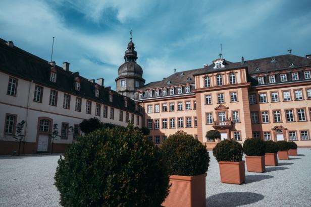 Ein Schloss mit einem Turm und mehreren Pflanzenkübeln im Innenhof.