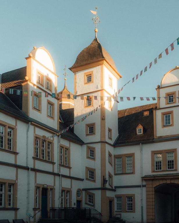 Ein weißes Gebäude mit einem Turm und vielen Flaggenketten.