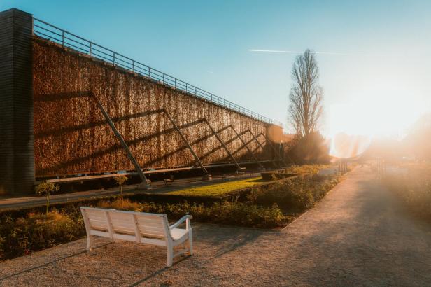 Ein Gradierwerk in einem Kurpark im Abendlicht.