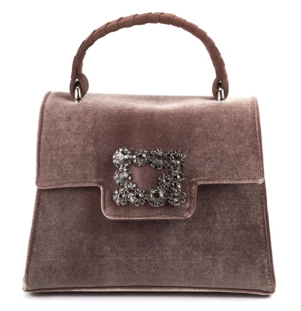 Eine braune Handtasche aus Samt mit einer verzierten Brosche.