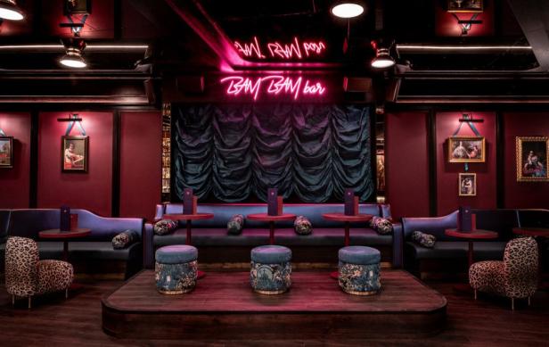 Interieur der Bam Karaoke Bar in London mit Bühne, Sitzgelegenheiten und Neonreklame.