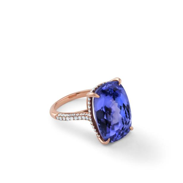 Ein Ring mit einem großen, blau-violetten Edelstein und Diamanten auf einem roségoldenen Band.