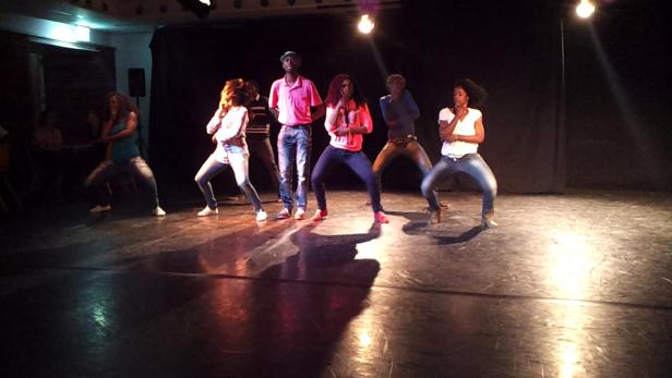 Eine Gruppe von Tänzern tritt auf einer Bühne auf.