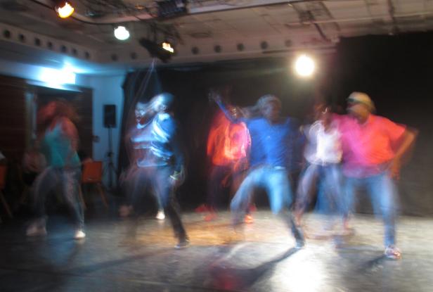 Eine Gruppe von Menschen tanzt auf einer Bühne.