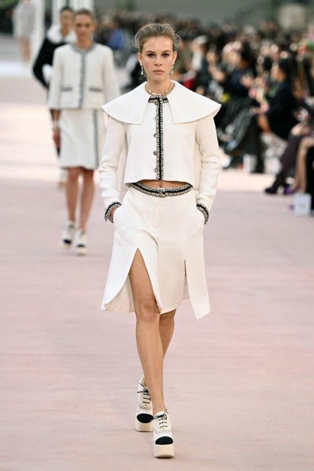 Ein Model in einem weißen Chanel-Ensemble auf dem Laufsteg.
