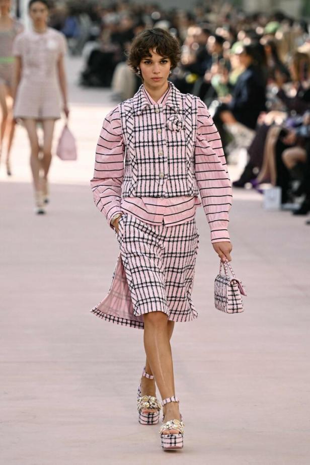 Ein Model in einem rosa-karierten Ensemble auf dem Laufsteg.