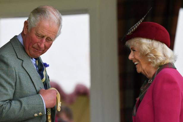 König Charles und Königin Camilla bei einer Veranstaltung in traditioneller Kleidung.