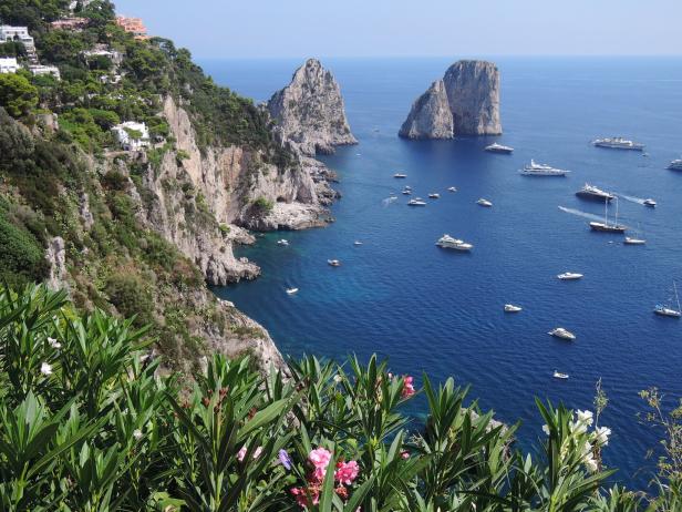 Blick auf die Faraglioni Felsen vor Capri, viele Ausflugsschiffe und Boote im Meer