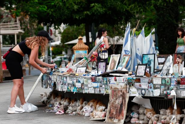 People look at pictures of hostages kidnapped during the deadly October 7 attack on Israel by Hamas, in Tel Aviv