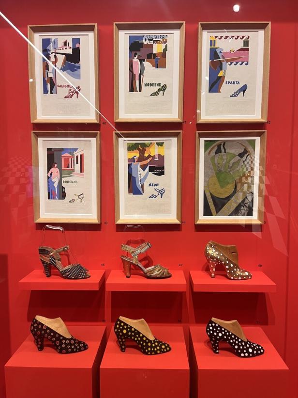 Ausstellung von Schuhen und Schuhwerbung im Art-Déco-Stil auf rotem Hintergrund.