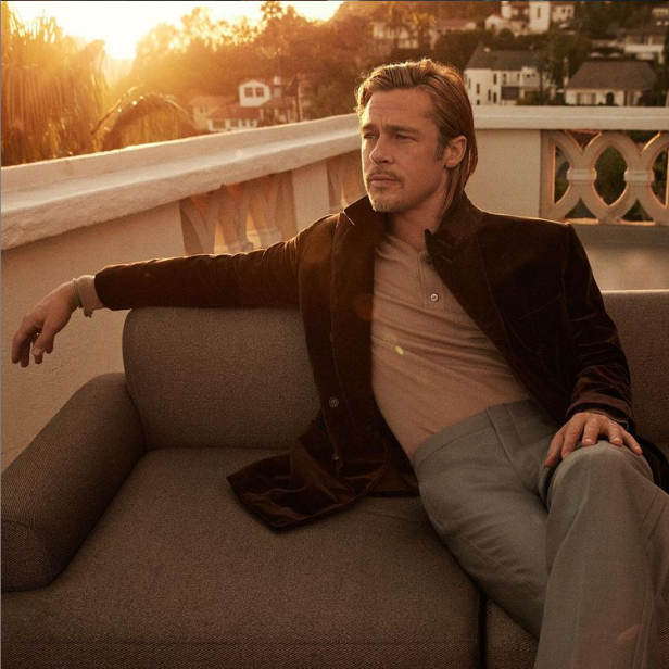 Brad Pitt sitzt auf einem Sofa auf einer Dachterrasse im goldenen Abendlicht.