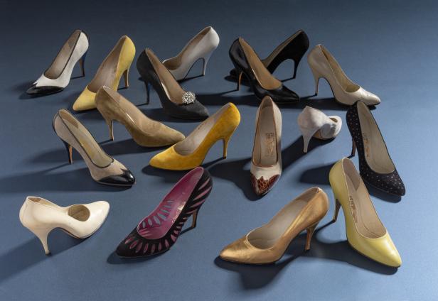 Eine Sammlung von eleganten Damenschuhen in verschiedenen Farben und Designs auf blauem Grund.