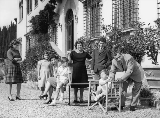 Eine Familie posiert vor einem großen Haus für ein Foto.