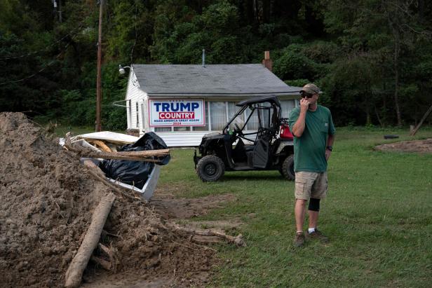 Ein Mann steht in der Nähe eines Hauses mit einem Trump-2024-Wahlkampfschild in North Carolina nach dem Durchzug des Hurrikans "Helene".