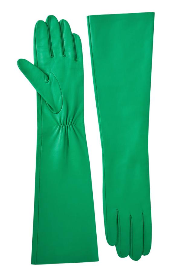 Ein Paar lange, grüne Lederhandschuhe liegen auf einem weißen Hintergrund.