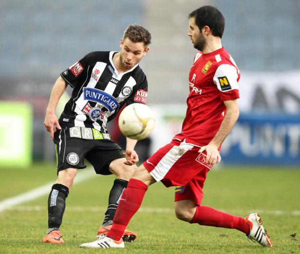 Zwei Fußballspieler kämpfen um den Ball während eines Fußballspiels.