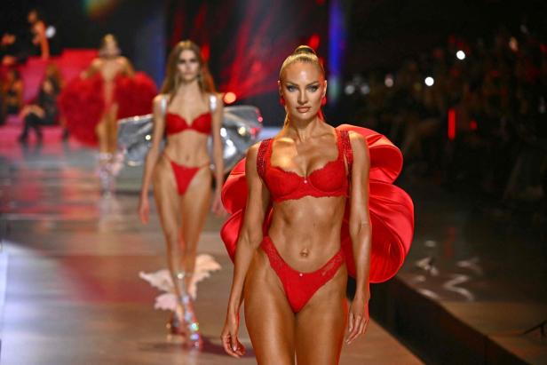Candice Swanepoel läuft in roter Unterwäsche und einem roten Umhang auf dem Laufsteg.
