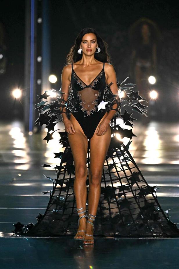 Irina Shayk läuft in einem schwarzen Body mit Sternenapplikationen über den Laufsteg.