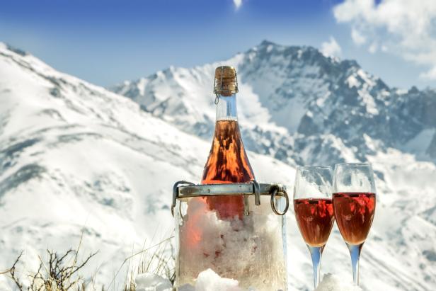 Rosé Wein vor Bergkulisse im Winter, Schnee und Sonnenschein