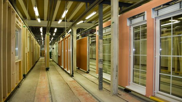 In einer Fabrikhalle werden vorgefertigte Wandelemente für den Hausbau transportiert.