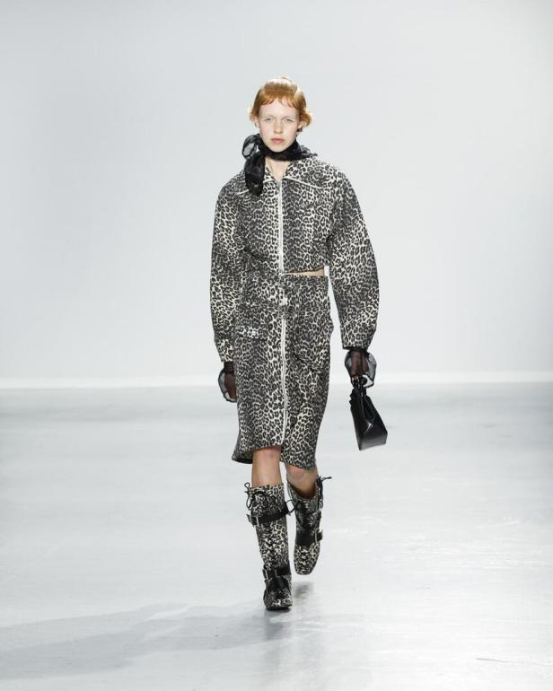 Ein Model präsentiert ein Outfit mit Leopardenmuster auf einem Laufsteg.