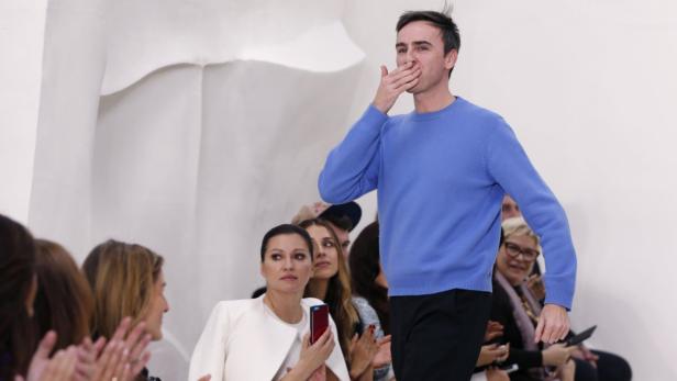 Ein Mann im blauen Pullover wirft dem applaudierenden Publikum einen Kuss zu.